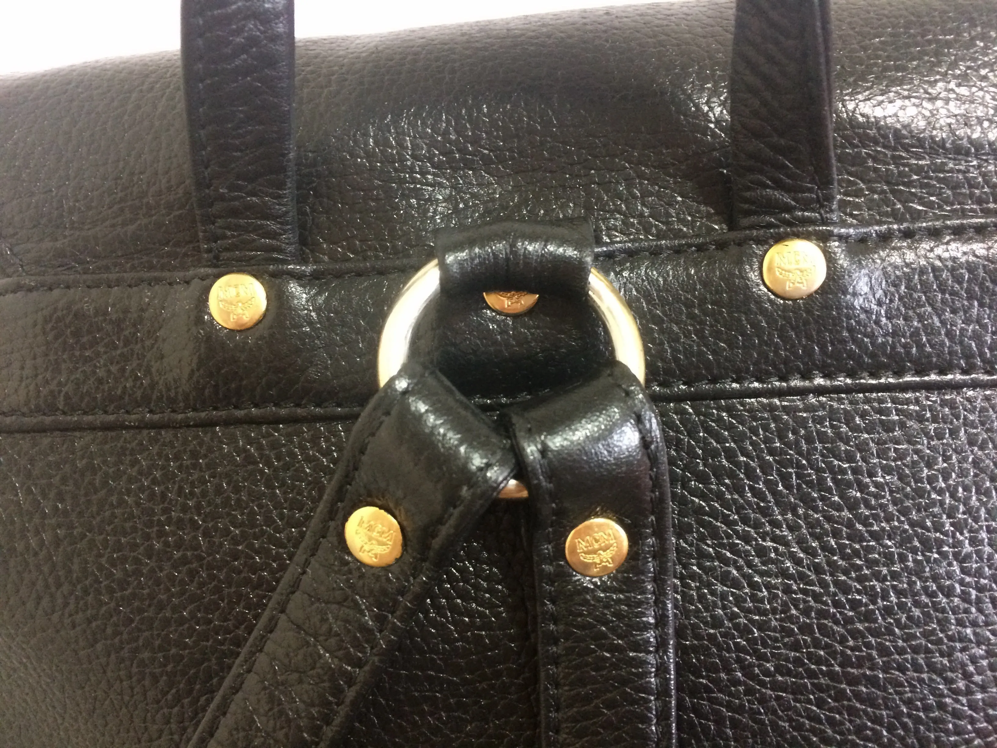 Vintage MCM black leather backpack with golden studded logo motifs. Designed by Michael Cromer. Unisex bag for daily use.
