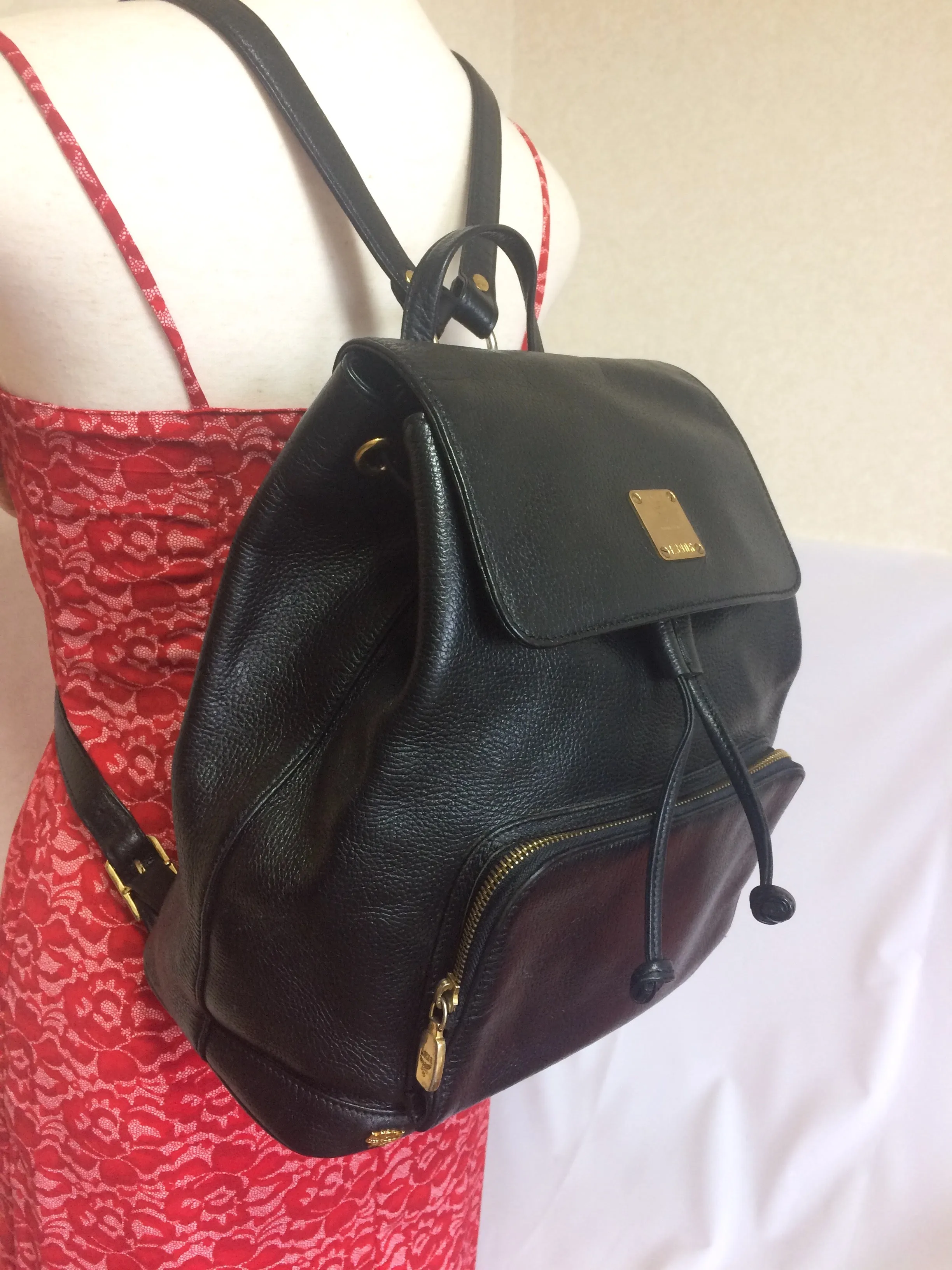 Vintage MCM black leather backpack with golden studded logo motifs. Designed by Michael Cromer. Unisex bag for daily use.