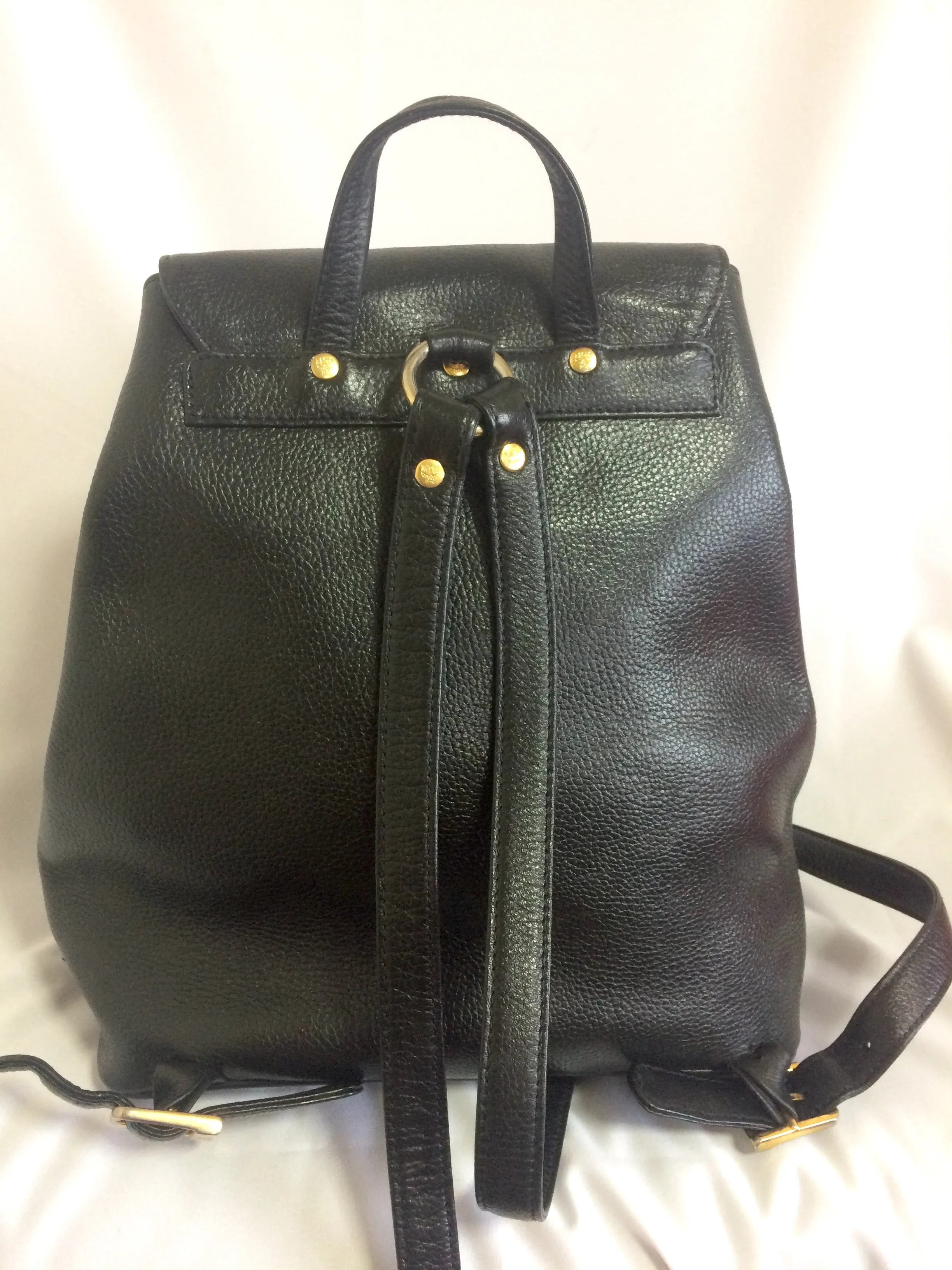 Vintage MCM black leather backpack with golden studded logo motifs. Designed by Michael Cromer. Unisex bag for daily use.