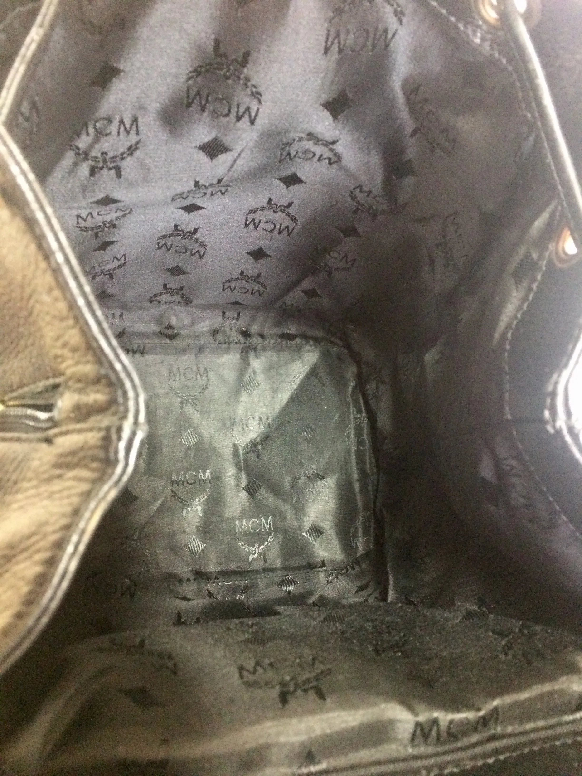Vintage MCM black leather backpack with golden studded logo motifs. Designed by Michael Cromer. Unisex bag for daily use.