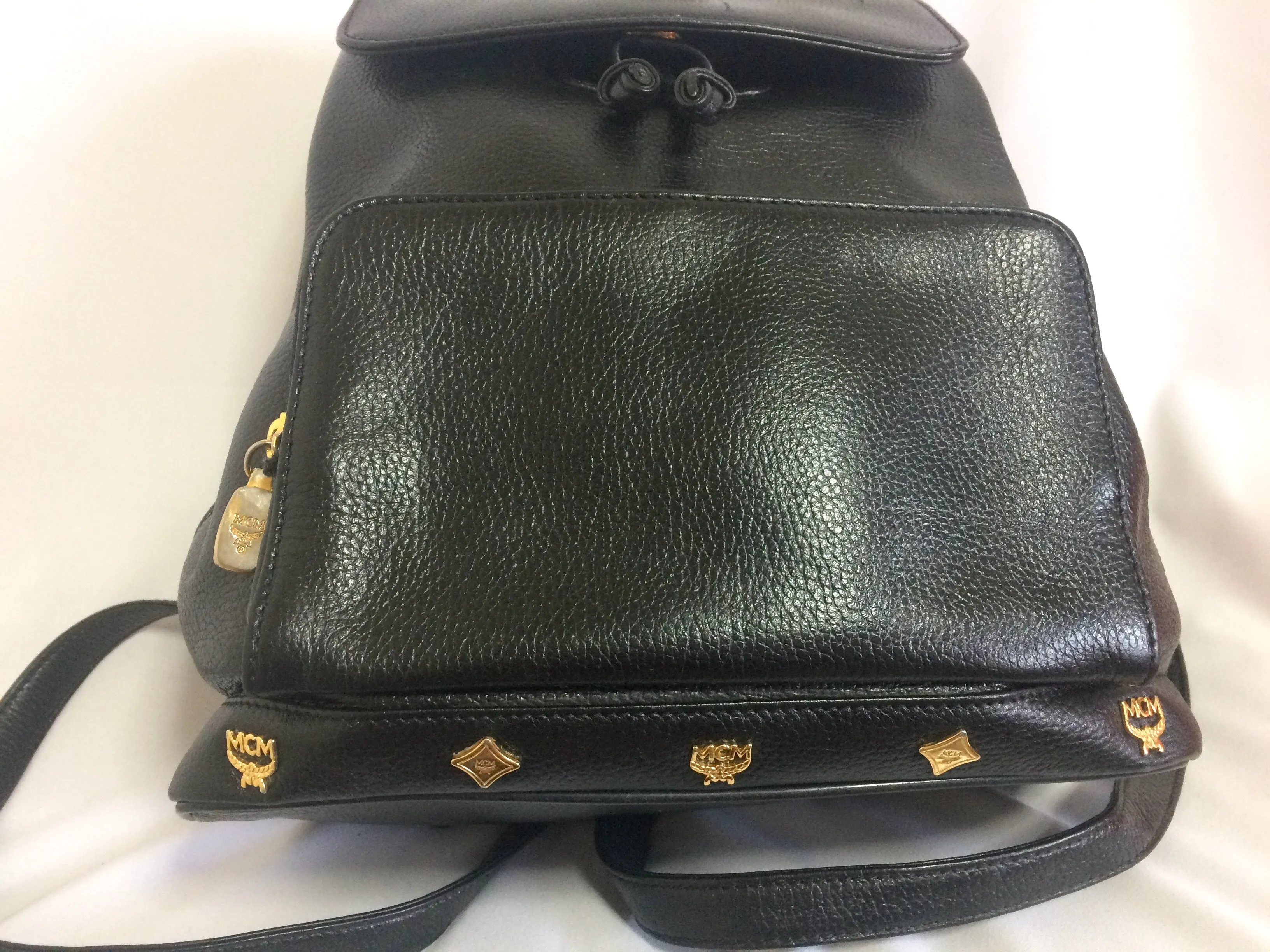 Vintage MCM black leather backpack with golden studded logo motifs. Designed by Michael Cromer. Unisex bag for daily use.