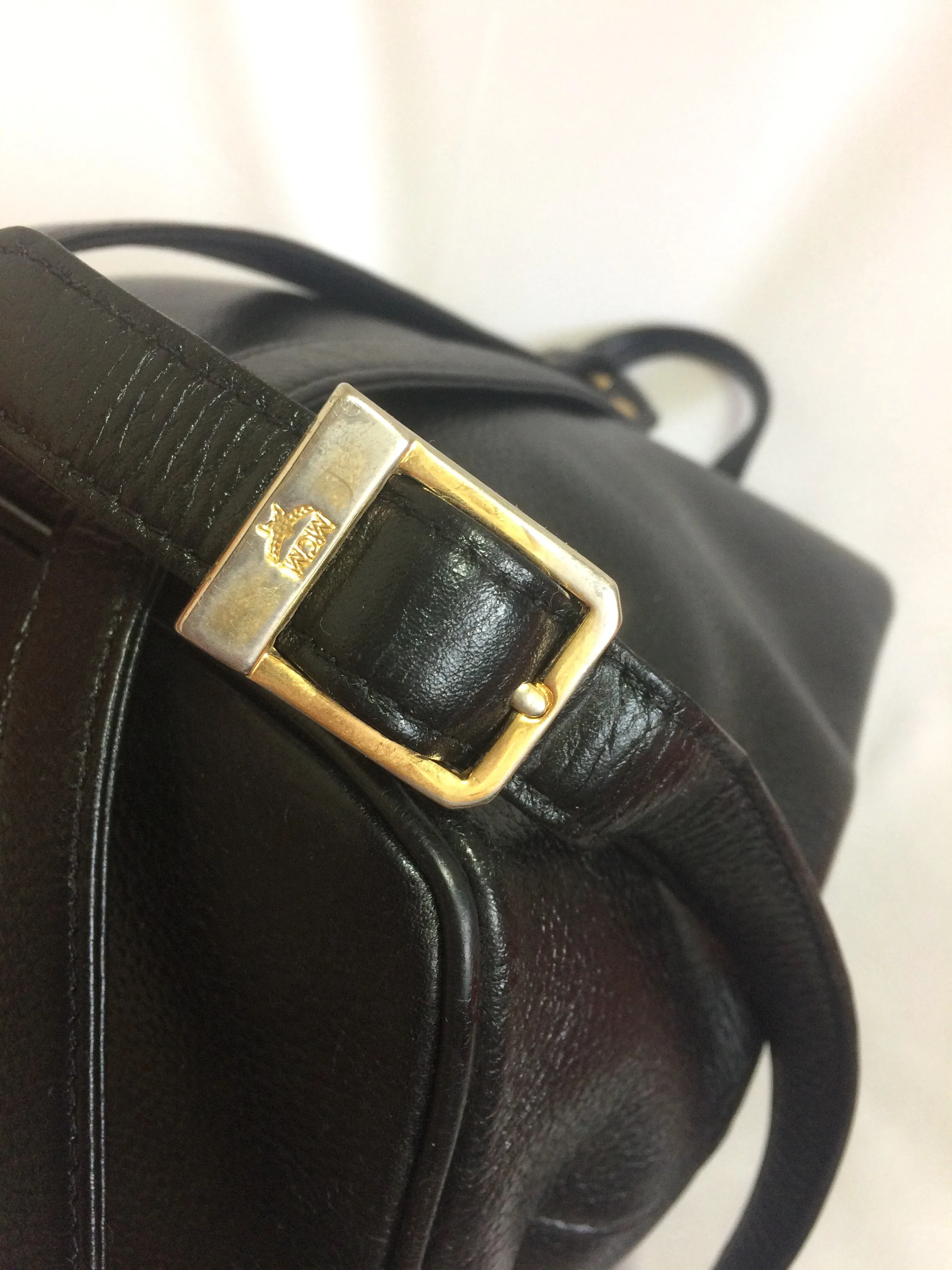 Vintage MCM black leather backpack with golden studded logo motifs. Designed by Michael Cromer. Unisex bag for daily use.