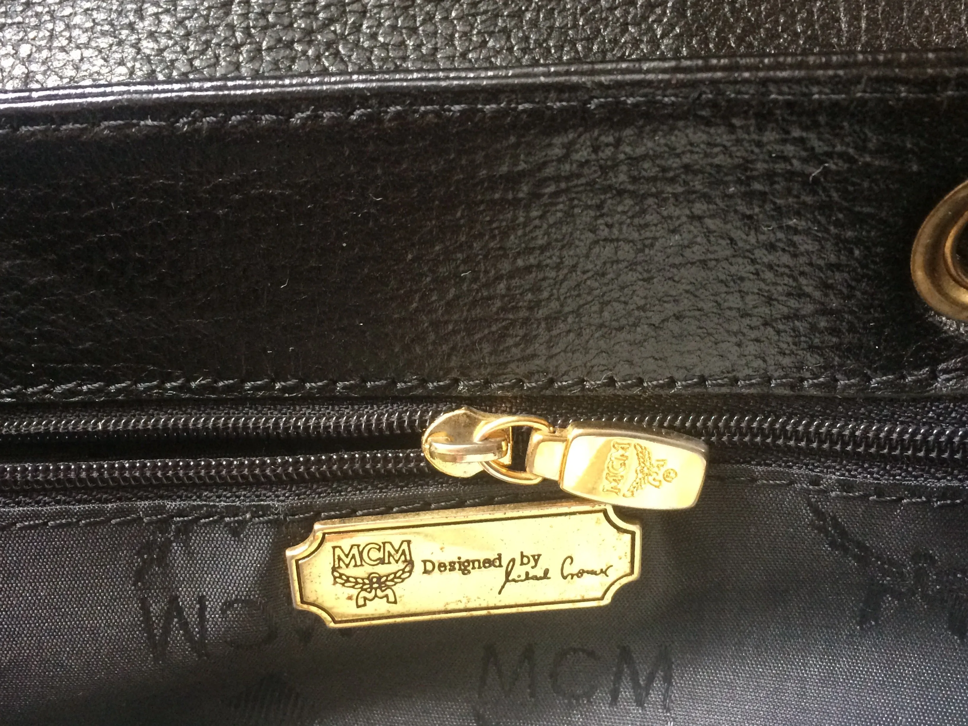 Vintage MCM black leather backpack with golden studded logo motifs. Designed by Michael Cromer. Unisex bag for daily use.