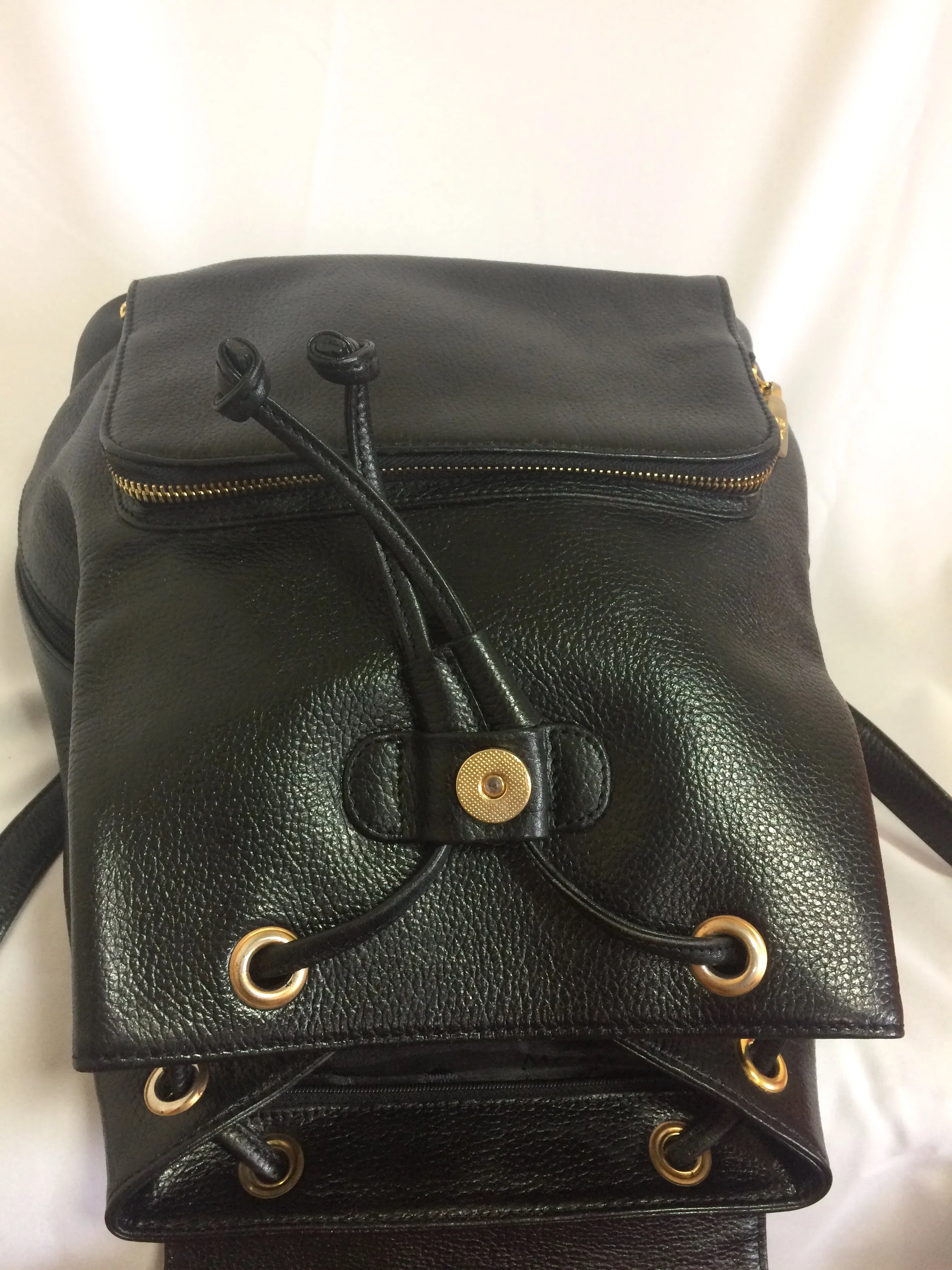 Vintage MCM black leather backpack with golden studded logo motifs. Designed by Michael Cromer. Unisex bag for daily use.