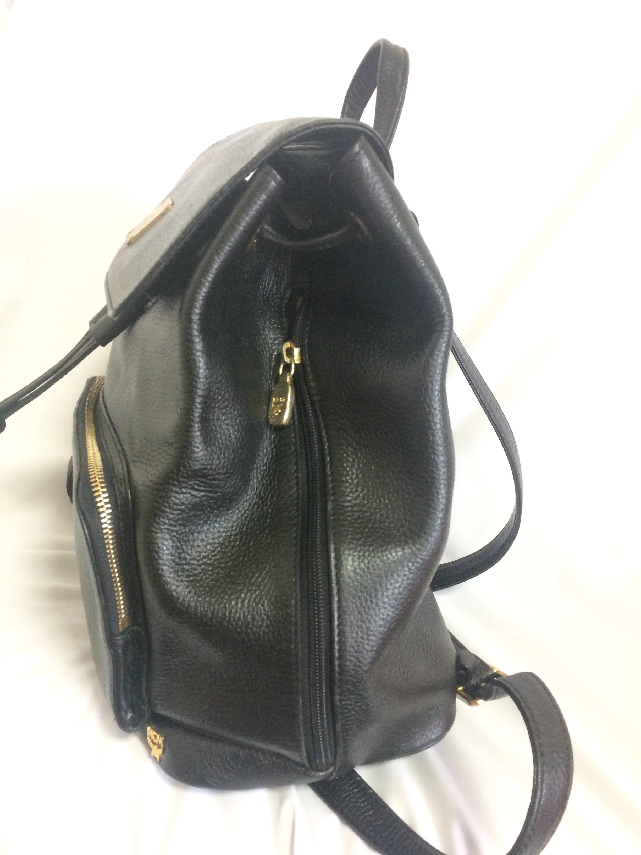 Vintage MCM black leather backpack with golden studded logo motifs. Designed by Michael Cromer. Unisex bag for daily use.